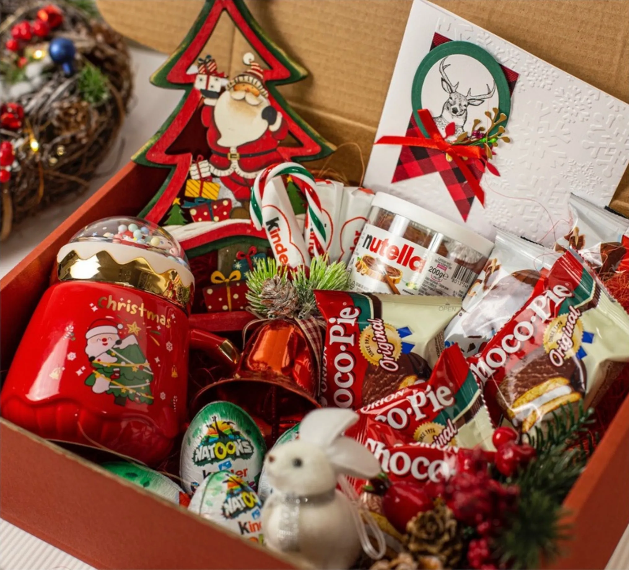 Cadoul pentru copii Christmas Box cu jucărie decorativă din lemn, cană de Crăciun, Nutella și dulciuri Kinder, într-o cutie kraft (fotografia 2 din 3)